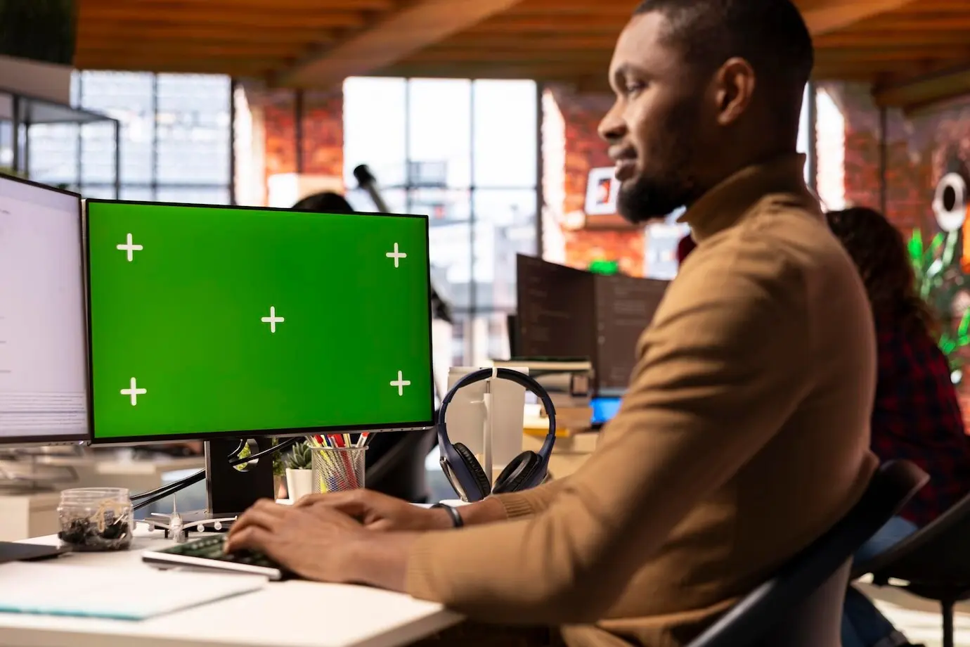 Программист пишет код в офисе стартапа в сфере ИИ, используя макет ПК.